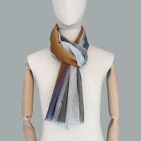 Mannequin wearing scarf on a gray background. Hand-painted silk cotton scarf by Otta-Italy, measuring 70 x 190 cm, featuring 
gray, purple and orange shades. Luxury Italian pure silk cotton blend accessory, soft, fresh and lightweight scarf for women and men.
