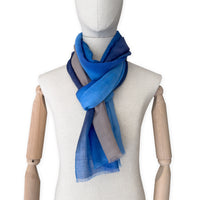 Mannequin wearing a blue and gray scarf on a white background. cashmere-scarf-hand-painted-69x207cm-indigo-sky-blue-midnight-blue-brown-otta-italy