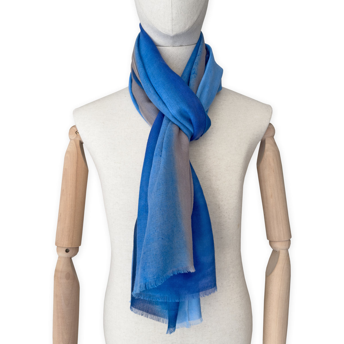 Mannequin wearing a blue scarf on a white background. cashmere-scarf-hand-painted-69x207cm-indigo-sky-blue-midnight-blue-brown-otta-italy