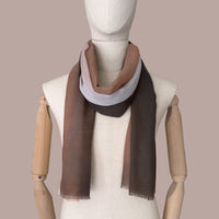 Mannequin wearing a hand-painted pure cashmere scarf by Otta-Italy, beige background. Brown, peach, beige and gray shades. 70 x 200 cm.
