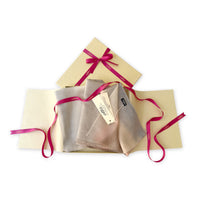 Set of scarves in a gift box with a pink ribbon on a white background. 
Hand-painted pure cashmere scarf by Otta-Italy, 66 x 200 cm, featuring light gray, beige, pink and brown. Luxury Italian cashmere accessory, soft and warm scarf for women and men.