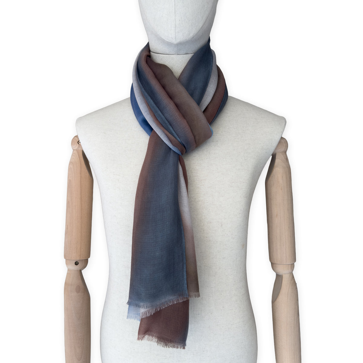 Mannequin wearing scarf on a white background. Hand-painted pure cashmere scarf by Otta-Italy, 67 x 200 cm, featuring dark gray, blue and brown. Luxury Italian cashmere accessory, soft and warm scarf for women and men.
