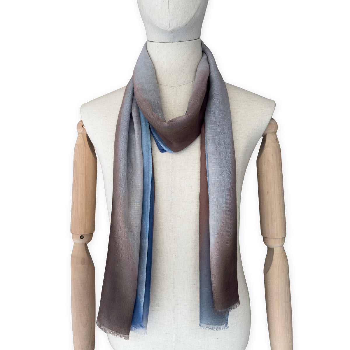 Mannequin wearing scarf on a white background. Hand-painted pure cashmere scarf by Otta-Italy, 67 x 200 cm, featuring dark gray, blue and brown. Luxury Italian cashmere accessory, soft and warm scarf for women and men.
