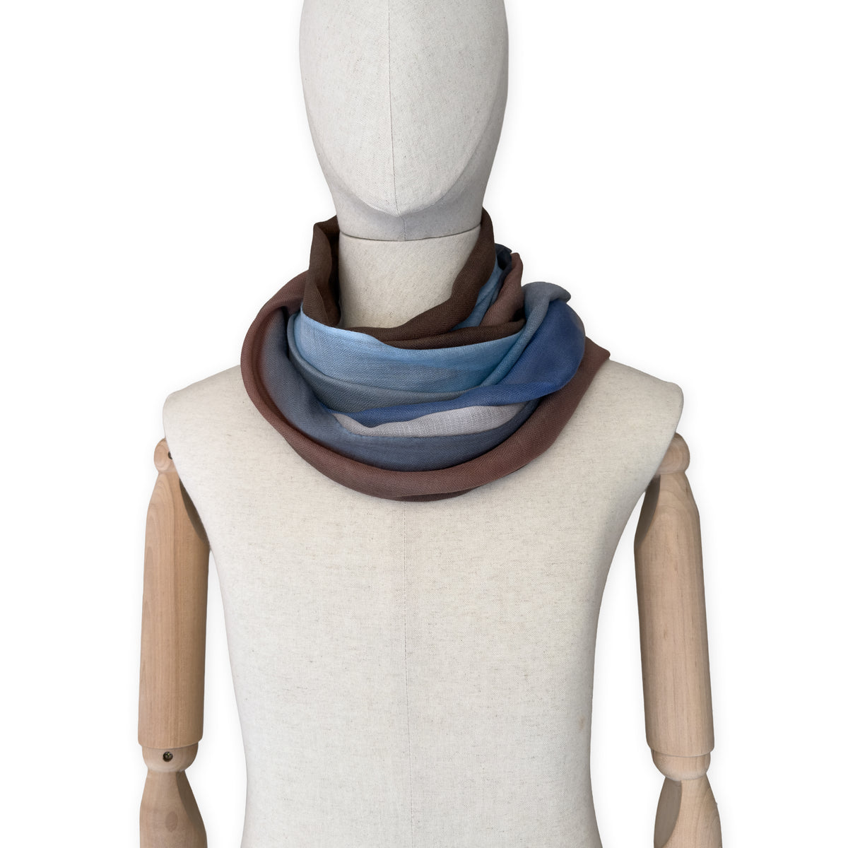 Mannequin wearing scarf on a white background. Hand-painted pure cashmere scarf by Otta-Italy, 67 x 200 cm, featuring dark gray, blue and brown. Luxury Italian cashmere accessory, soft and warm scarf for women and men.
