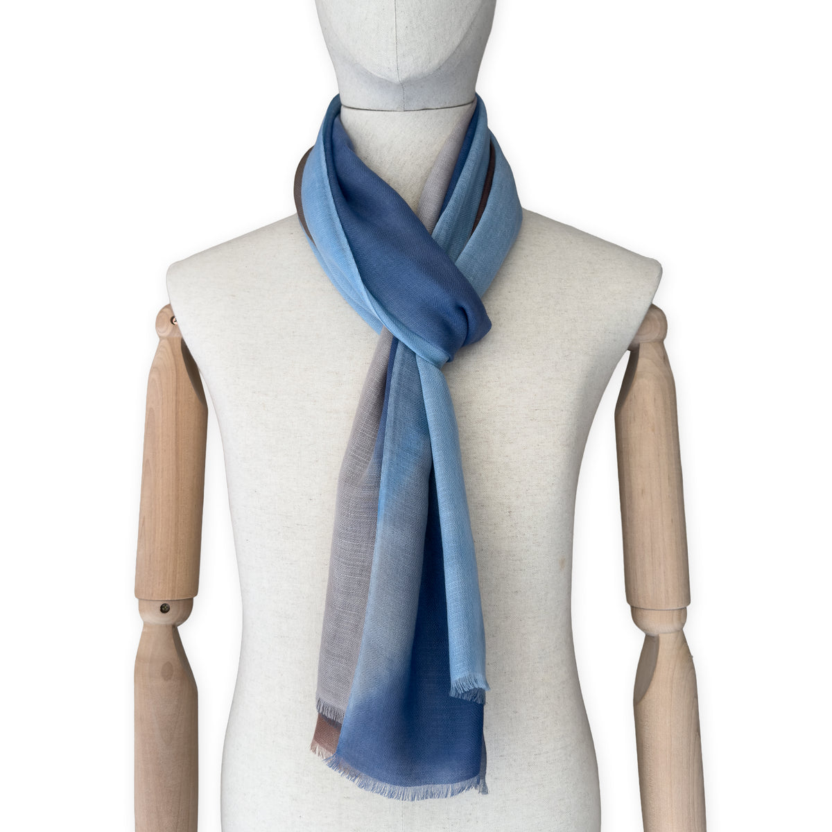 Mannequin wearing scarf on a white background. Hand-painted pure cashmere scarf by Otta-Italy, 67 x 200 cm, featuring dark gray, blue and brown. Luxury Italian cashmere accessory, soft and warm scarf for women and men.
