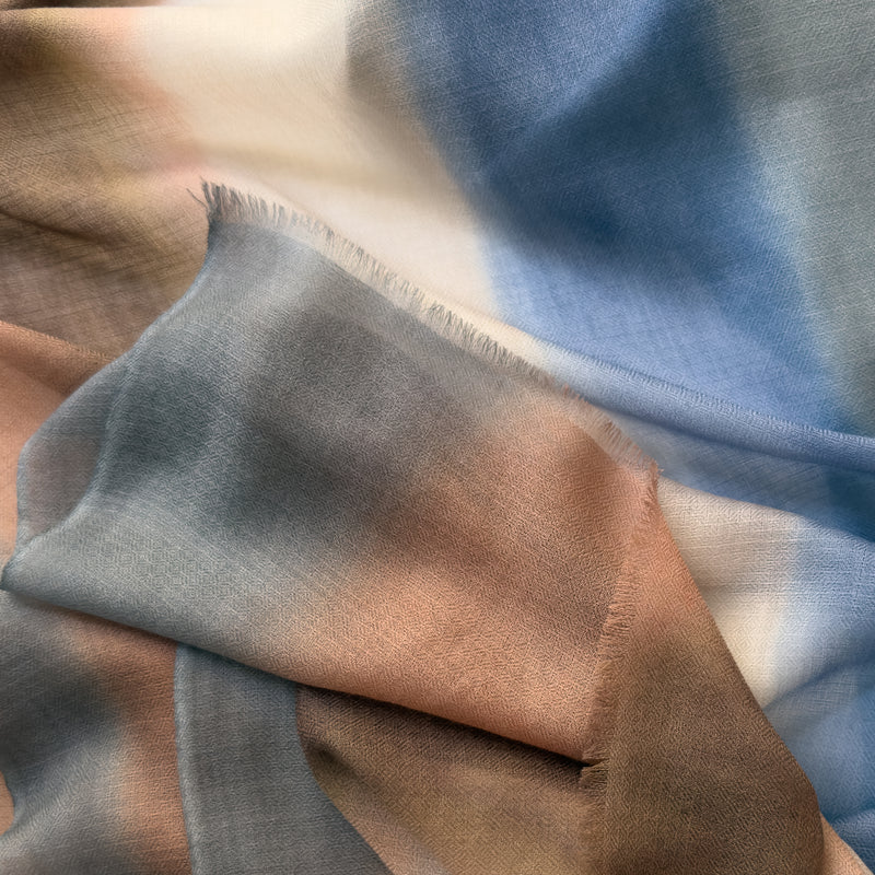 Close-up of a hand-painted Otta-Italy pure cashmere scarf showcasing rich shades of dark gray and brown with delicate hand-fringed edges and ultra-soft woven texture.