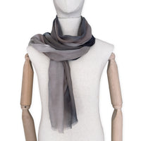 Mannequin wearing scarf on a white background. Hand-painted pure cashmere scarf by Otta-Italy, 67 x 200 cm, featuring dark gray and brown. Luxury Italian cashmere accessory, soft and warm scarf for women and men.
