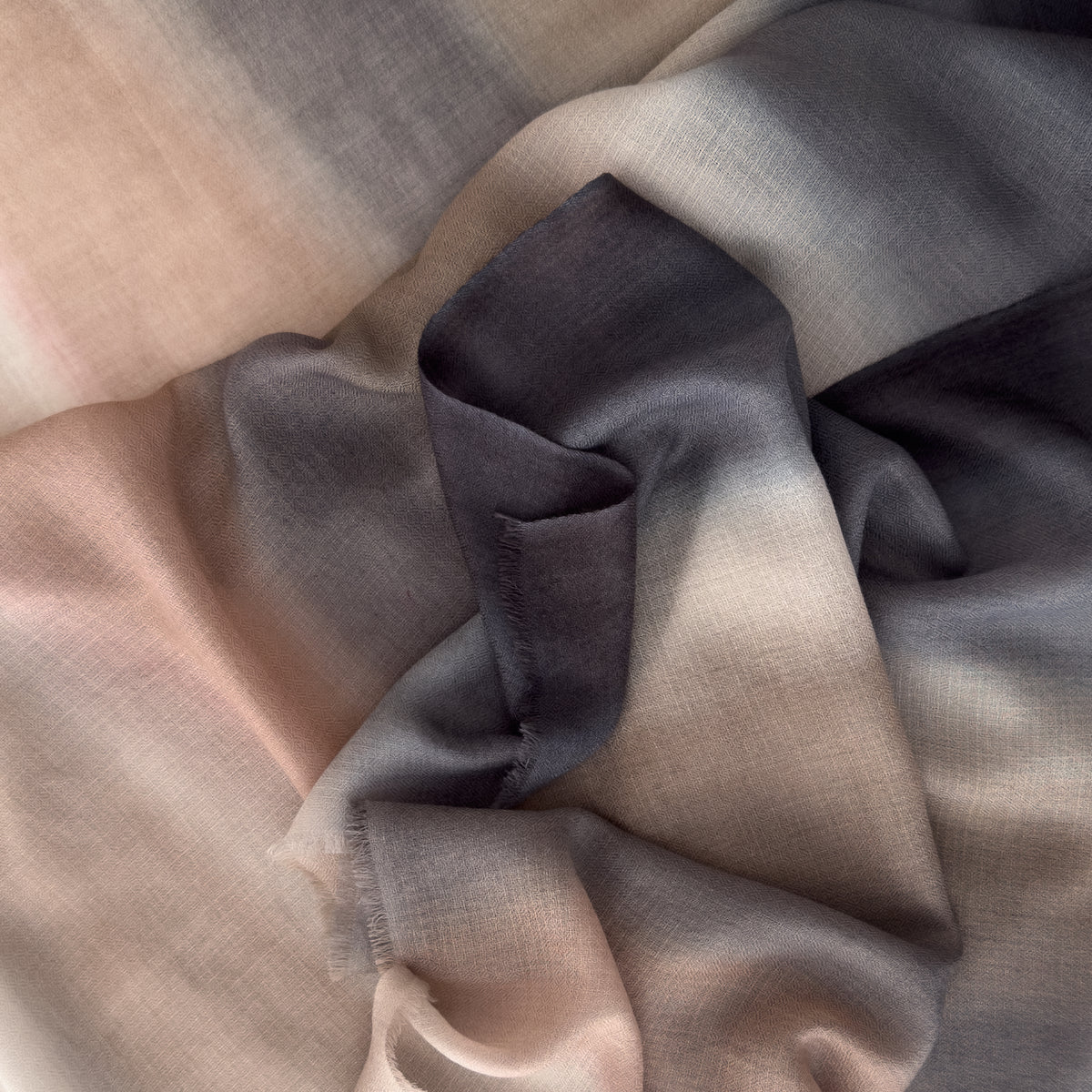 Close-up of soft fabric. Hand-painted pure cashmere scarf by Otta-Italy, 67 x 200 cm, featuring dark gray and brown. Luxury Italian cashmere accessory, soft and warm scarf for women and men.
