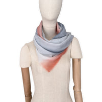 Mannequin wearing scarf on a white background. Hand-painted pure cashmere scarf by Otta-Italy, 66 x 198 cm, featuring grey and coral. Luxury Italian cashmere accessory, soft and warm scarf for women and men.
