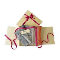 Set of scarves in a gift box with a pink ribbon on a white background. 
Hand-painted pure cashmere scarf by Otta-Italy, 66 x 198 cm, featuring grey and coral. Luxury Italian cashmere accessory, soft and warm scarf for women and men.
