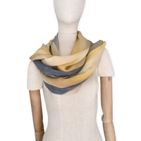 Mannequin wearing scarf on a white background. Hand-painted pure cashmere scarf by Otta-Italy, 66 x 198 cm, featuring ochre, yellow and grey. Luxury Italian cashmere accessory, soft and warm scarf for women and men.
