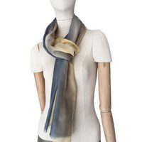 Mannequin wearing scarf on a white background. Hand-painted pure cashmere scarf by Otta-Italy, 66 x 198 cm, featuring ochre, yellow and grey. Luxury Italian cashmere accessory, soft and warm scarf for women and men.
