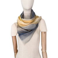 Mannequin wearing scarf on a white background. Hand-painted pure cashmere scarf by Otta-Italy, 66 x 198 cm, featuring ochre, yellow and grey. Luxury Italian cashmere accessory, soft and warm scarf for women and men.

