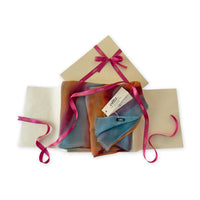 Set of scarves in a gift box with a pink ribbon on a white background. 
Hand-painted cashmere scarf by Otta-Italy, 69 x 201 cm, featuring 
orange, red and blue. Luxury Italian pure cashmere accessory, soft and warm scarf for women and men.
