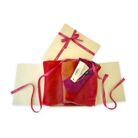 Set of scarves in a gift box with a pink ribbon on a white background. 
Hand-painted pure cashmere scarf by Otta-Italy, 66 x 200 cm, featuring red, fuchsia and orange. Luxury Italian cashmere accessory, soft and warm scarf for women and men.
