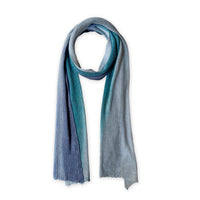Colorful linen scarf in blue, midnight blue, light blue, turquoise and indigo shades on a white background. t is hand-painted scarf in measures 32 x 200 cm by otta-italy scarves brand. Luxury Italian linen accessory, soft and lightweight scarf for women and men.
