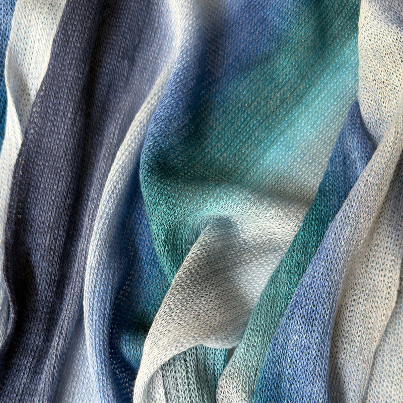 Close-up of fabric. Hand-painted linen scarf by Otta-Italy, 32 x 200 cm, featuring blue, midnight blue, light blue, turquoise and indigo colors. Luxury Italian linen scarf, soft and lightweight scarf for women and men.
