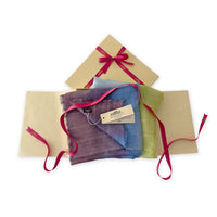 Set of scarves in a gift box with a pink ribbon on a white background. 
Hand-painted linen scarf by Otta-Italy, 70 x 190 cm, featuring 
blue, turquoise, green and purple. Luxury Italian pure linen accessory, soft, fresh and lightweight scarf for women and men.
