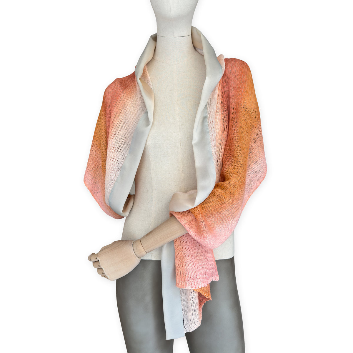 Mannequin wearing a hand-painted Otta pure linen scarf on a white background in 
coral, orange, gray, and champagne tones. soft, fresh and lightweight, and elegant accessory measuring 37 x 196 cm. Unique artisan scarf with hand-sewn edges, perfect for women and men.
