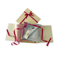 Set of scarves in a gift box with a pink ribbon on a white background. 
Hand-painted linen scarf by Otta-Italy, 70 x 190 cm, featuring 
pink, peach, fuchsia and gray. Luxury Italian pure linen accessory, soft, fresh and lightweight scarf for women and men.
