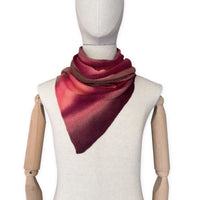 Mannequin wearing a colorful and lightweight linen scarf on a white background. Linen scarf is in shades of red, coral and brown colors. It is hand-painted scarf in measures 32 x 200 cm by otta-italy scarves brand. Luxury Italian linen, soft and lightweight scarf for women and men.
