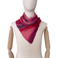 Mannequin wearing a hand-painted Otta pure linen scarf on a white background in 
red and purple tones. soft, fresh and lightweight, and elegant accessory measuring 33 x 205 cm. Unique artisan scarf with hand-sewn edges, perfect for women and men.
