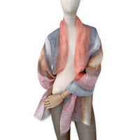 Mannequin wearing a hand-painted Otta pure linen scarf on a white background in 
coral, gray, brown, pink and blue tones. soft, fresh and lightweight, and elegant accessory measuring 52 x 200 cm. Unique artisan scarf with hand-sewn edges, perfect for women and men.
