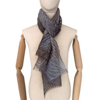 
Mannequin wearing a hand-painted Otta pure linen scarf on a white background in 
brown, gray and blue tones. soft, fresh and lightweight, and elegant accessory measuring 51x 202 cm. Unique artisan scarf with hand-sewn edges, perfect for women and men.
