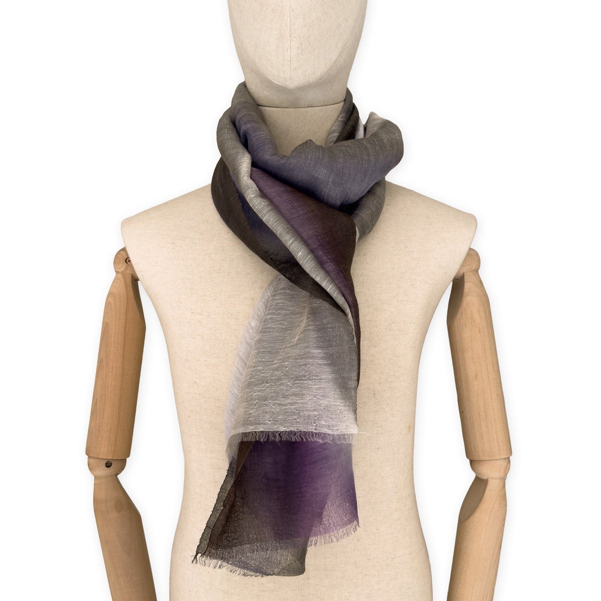 Mannequin wearing an elegant hand-painted Otta linen silk blend scarf on a white background. Indigo, light blue, purple, brown and beige tones.
