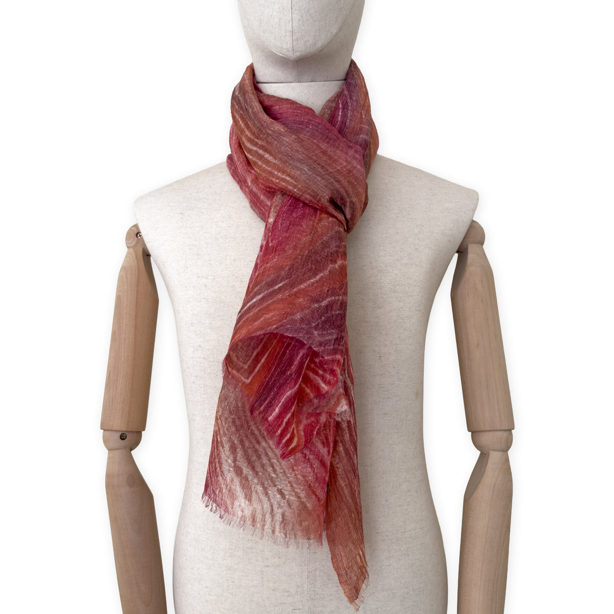 Mannequin wearing a hand-painted Otta pure linen scarf on a white background in 
brown and red tones. soft, fresh and lightweight, and elegant accessory measuring 203 x 50 cm. Unique artisan scarf with hand-sewn edges, perfect for women and men.
