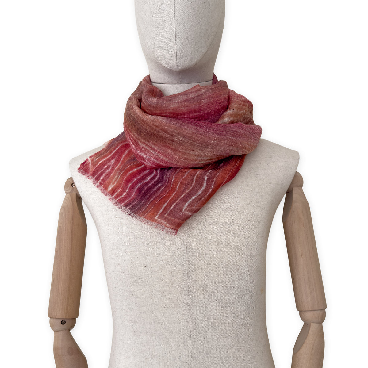 Mannequin wearing a hand-painted Otta pure linen scarf on a white background in 
brown and red tones. soft, fresh and lightweight, and elegant accessory measuring 203 x 50 cm. Unique artisan scarf with hand-sewn edges, perfect for women and men.
