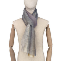 Mannequin wearing an elegant hand-painted Otta-Italy linen silk blend scarf on a white background. Yellow, ochre, sapphire, and gray tones.


