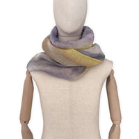 Mannequin wearing an elegant hand-painted Otta-Italy linen silk blend scarf on a white background. Yellow, ochre, sapphire, and gray tones.


