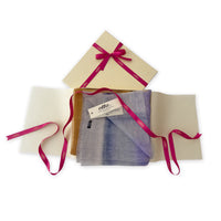 Luxury gift box with a pink ribbon containing a hand-painted Otta-Italy linen silk blend scarf on a white background.


