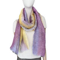 Mannequin wearing a hand-painted Otta pure linen scarf on a white background in 
yellow, purple and lilac tones. soft, fresh and lightweight, and elegant accessory measuring 52 x 200 cm. Unique artisan scarf with hand-sewn edges, perfect for women and men.
