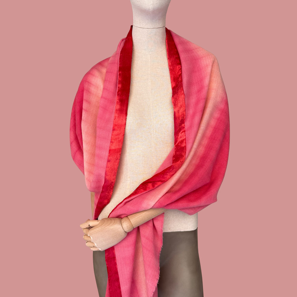 Mannequin wearing scarf on a pink background. Hand-painted mix cashmere and wool scarf by Otta-Italy, 57 x 180 cm, featuring red, fuchsia and pink colors. Luxury Italian mix cashmere and wool accessory, soft and warm scarf for women and men.
