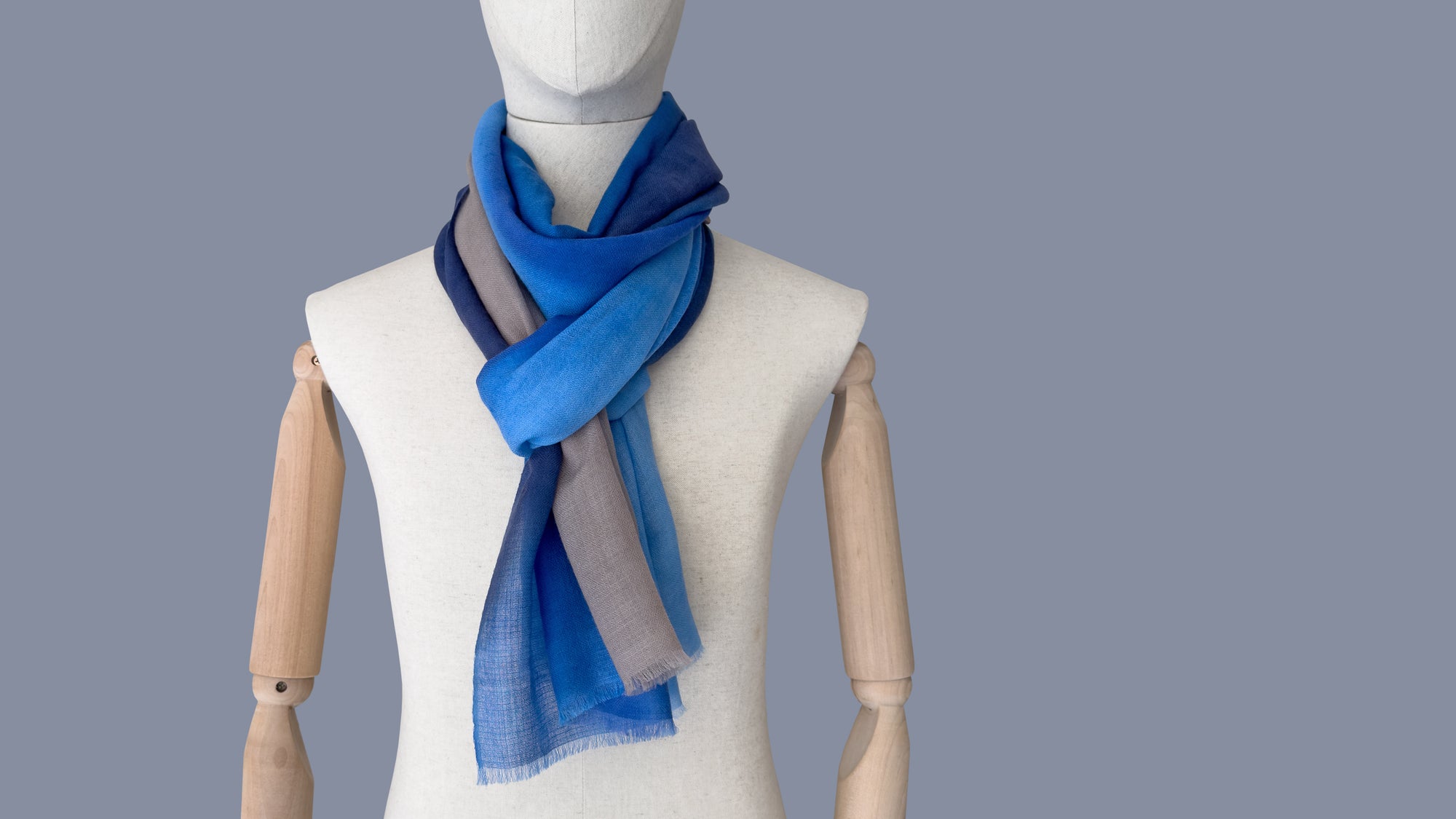 Mannequin wearing a blue scarf on a gray background