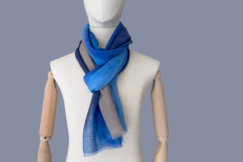 Mannequin wearing a blue scarf on a gray background