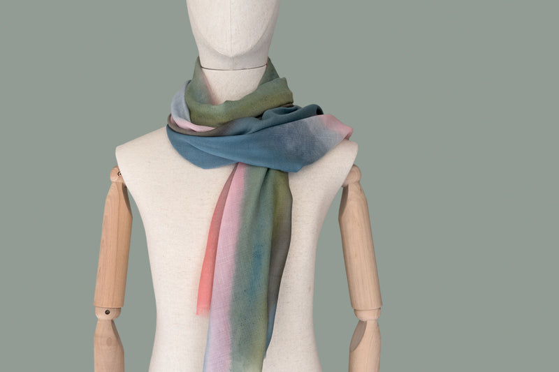 Mannequin wearing a colorful scarf on a plain background
