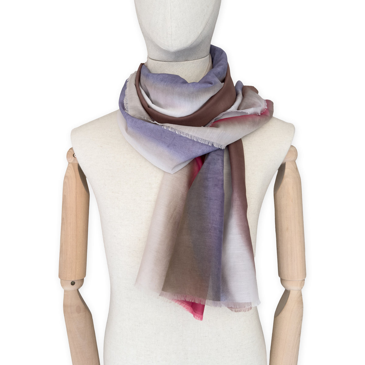 Mannequin wearing a hand-painted Otta silk cotton blend scarf on a white background in 
brown, beige, red and purple tones. soft, fresh and lightweight, and elegant accessory measuring 70 x 190 cm. Unique artisan scarf with hand-fringed edges, perfect for women and men.

