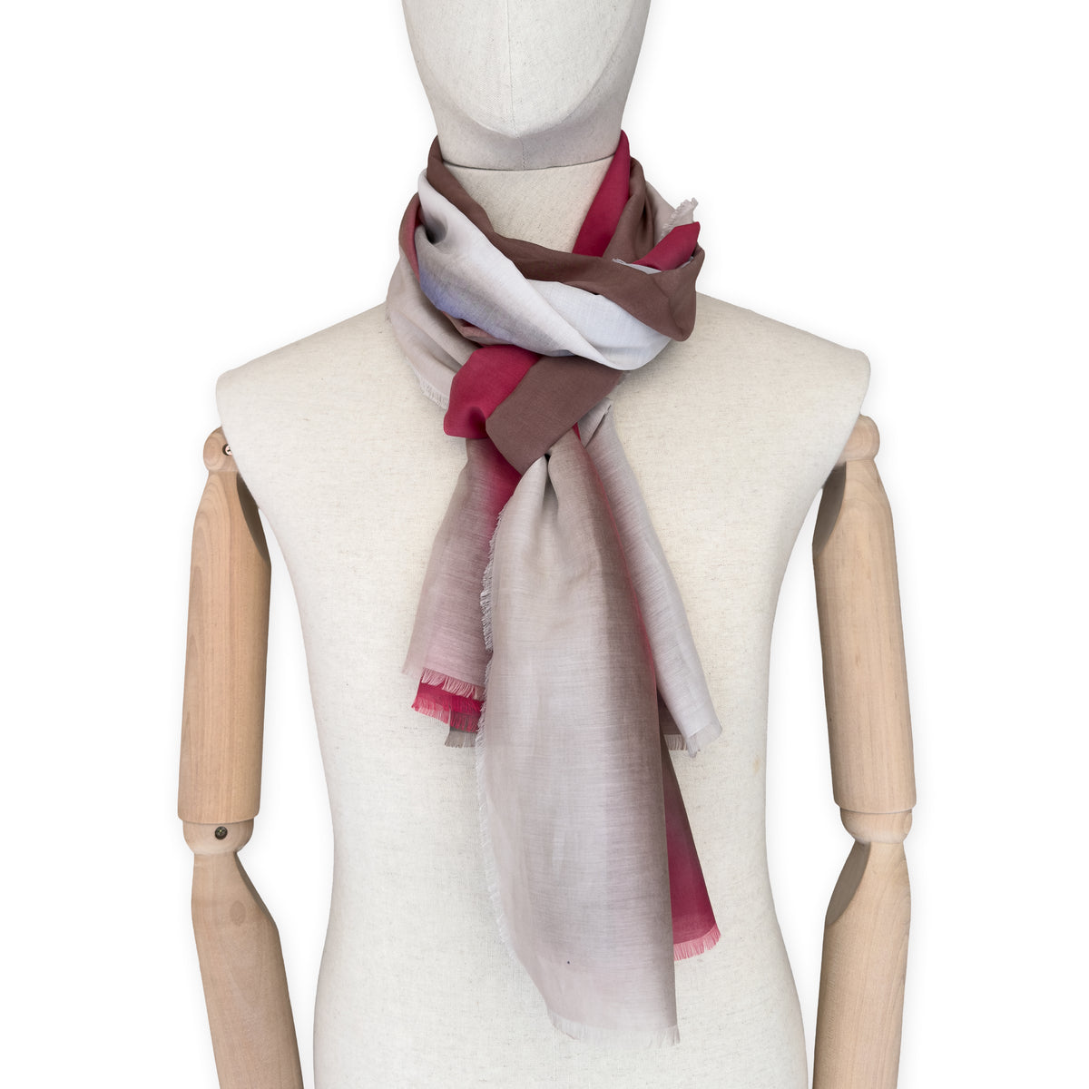 Mannequin wearing a hand-painted Otta silk cotton blend scarf on a white background in 
brown, beige, red and purple tones. soft, fresh and lightweight, and elegant accessory measuring 70 x 190 cm. Unique artisan scarf with hand-fringed edges, perfect for women and men.
