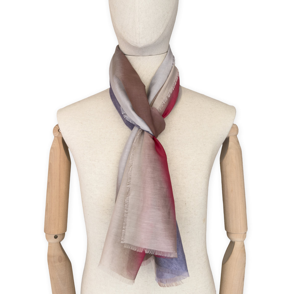 Mannequin wearing a hand-painted Otta silk cotton blend scarf on a white background in 
brown, beige, red and purple tones. soft, fresh and lightweight, and elegant accessory measuring 70 x 190 cm. Unique artisan scarf with hand-fringed edges, perfect for women and men.

