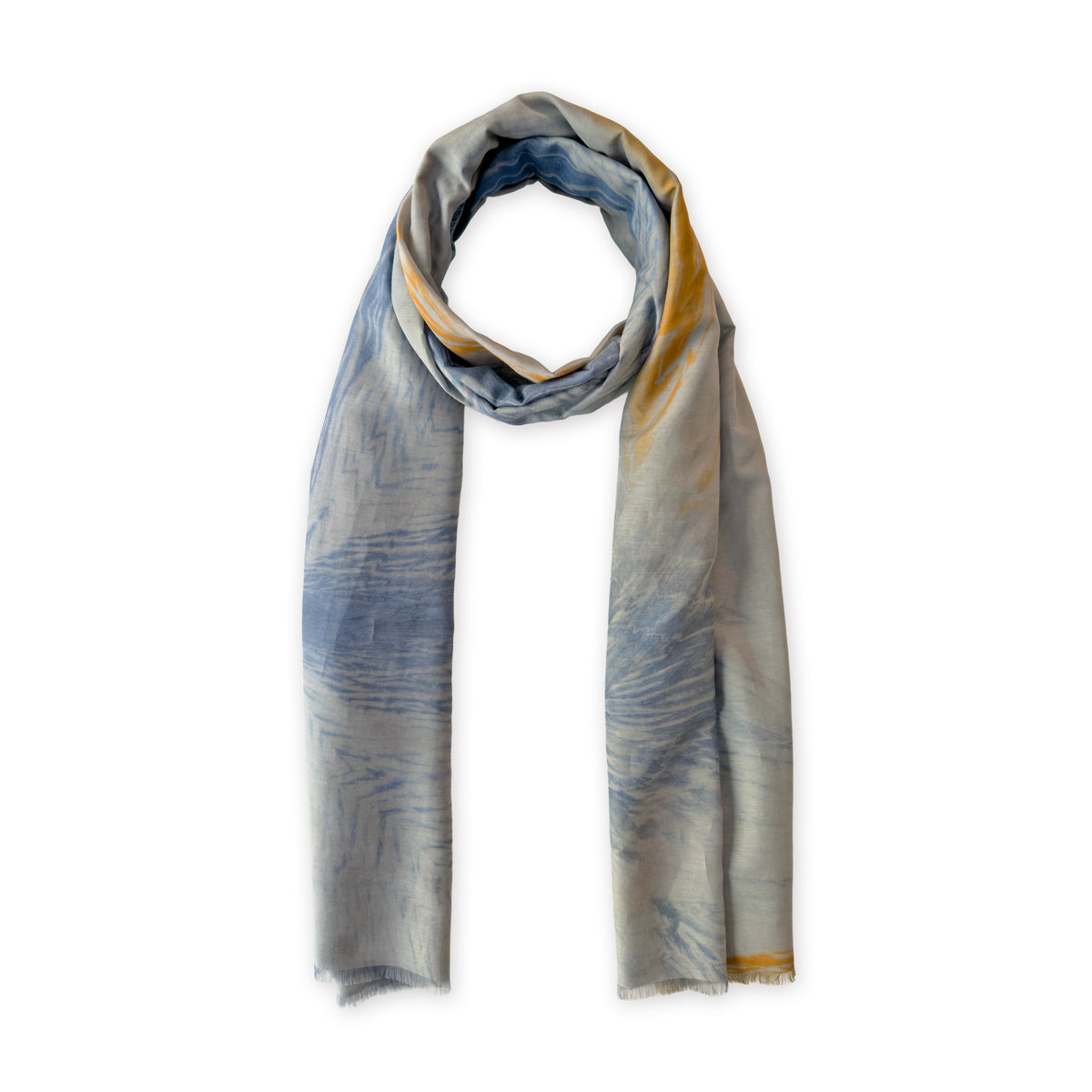 A hand-painted Otta silk cotton blend scarf on a white background, in 
blue, gray and orange shades, loosely looped to showcase its full length and delicate texture. Lightweight artisan accessory with hand-fringed edges, measuring 67 x 193 cm.

