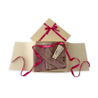 Luxury gift box with a pink ribbon containing a hand-painted Otta pure silk organza scarf on a white background.
