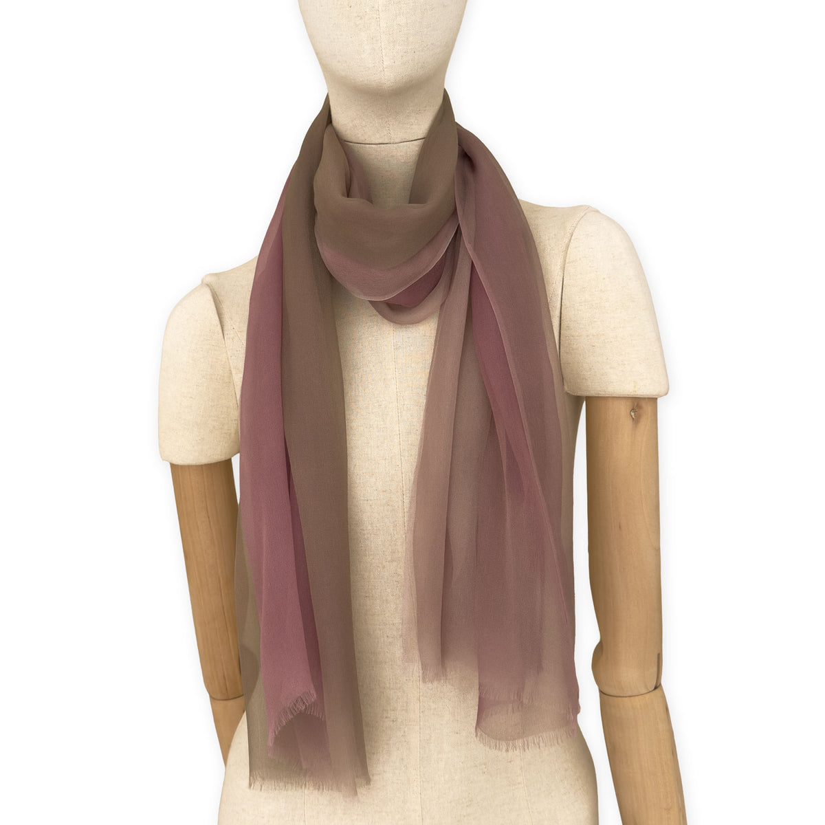 Mannequin wearing an elegant hand-painted Otta pure silk organza scarf on a gray background. Pink, beige and brown tones.
