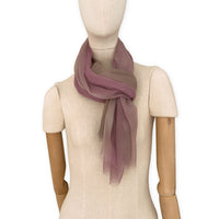 Mannequin wearing an elegant hand-painted Otta pure silk organza scarf on a gray background. Pink, beige and brown tones.
