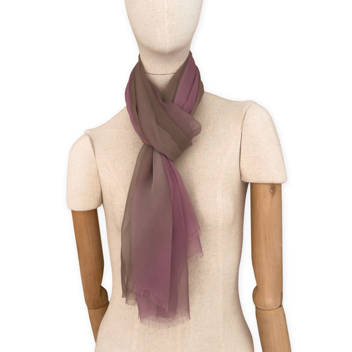 Mannequin wearing an elegant hand-painted Otta pure silk organza scarf on a gray background. Pink, beige and brown tones.
