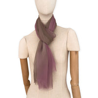 Mannequin wearing an elegant hand-painted Otta pure silk organza scarf on a gray background. Pink, beige and brown tones.
