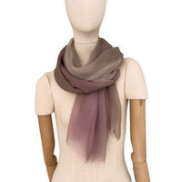 Mannequin wearing an elegant hand-painted Otta pure silk organza scarf on a gray background. Pink, beige and brown tones.
