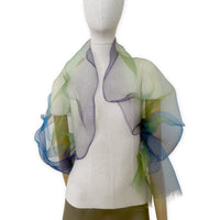 Mannequin wearing an elegant hand-painted Otta pure silk organza scarf on a gray background. Blue, green and violet tones.
